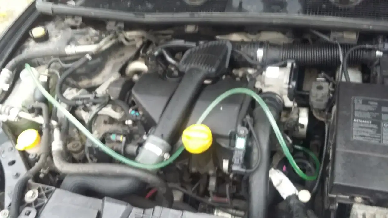 Silnik Renault Megane z widocznym zbiorniczkiem płynu chłodniczego. Sprawdzanie, ile wchodzi płynu chłodniczego do renault megane, jest kluczowe dla jego prawidłowego działania.