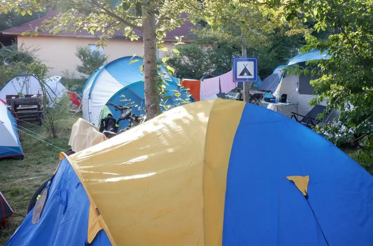 Kolorowe namioty na kempingu, gdzie pod namiot można zabrać rower i suszyć pranie.