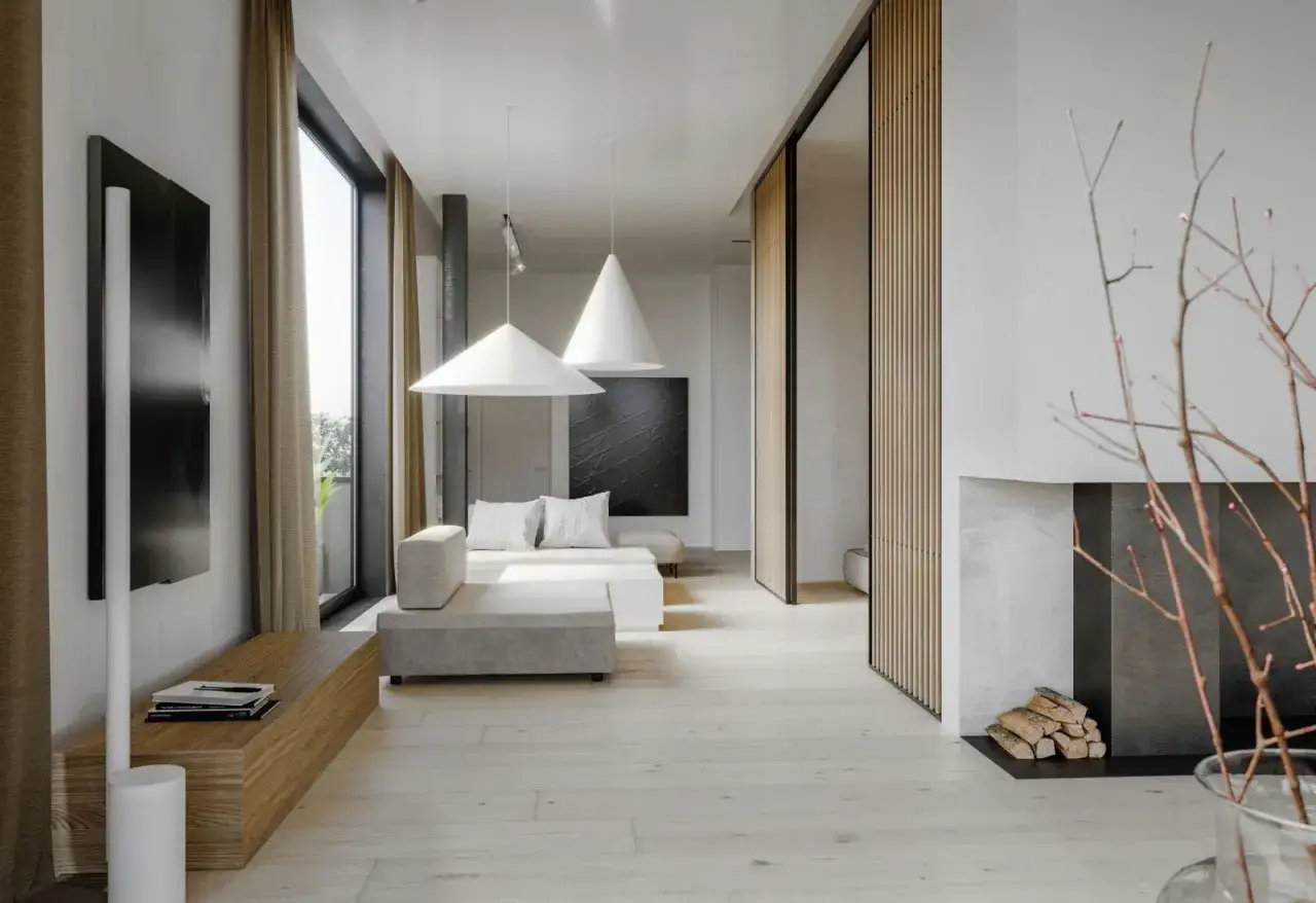 Minimalistyczny salon w stylu zen. Jasne drewno, szara sofa, kominek i subtelne dekoracje tworzą oazę spokoju.