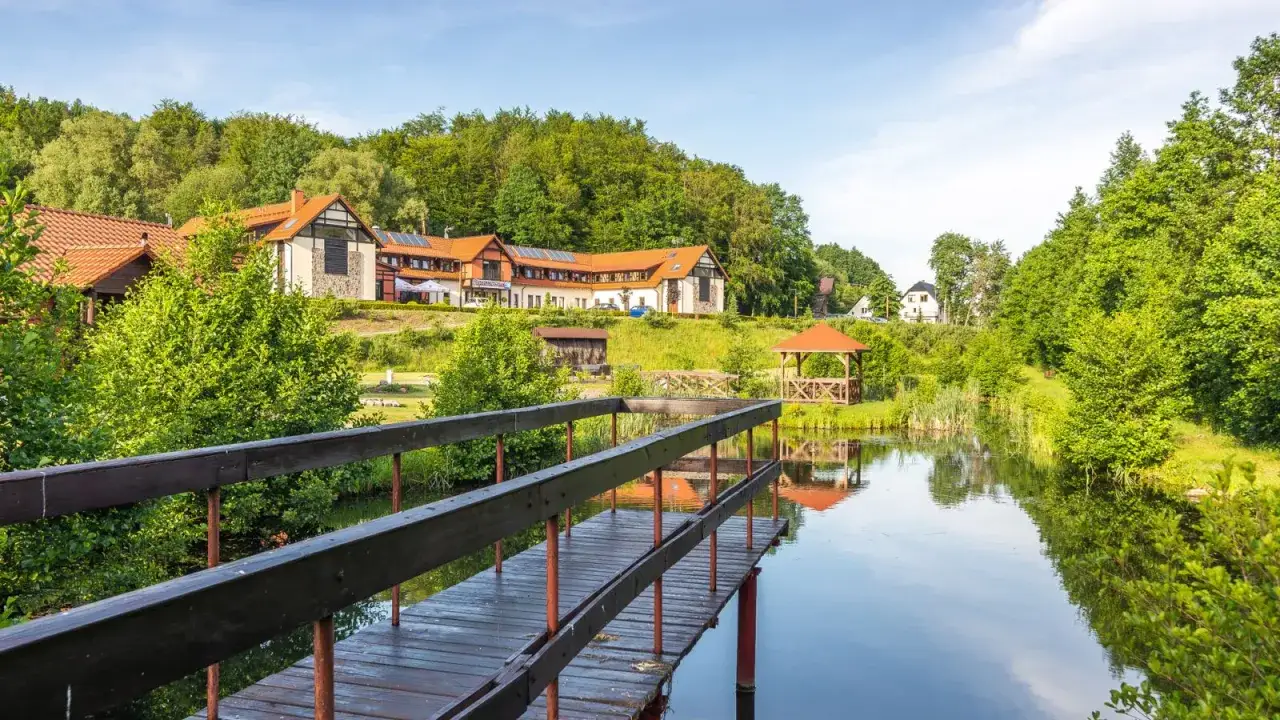 Malowniczy hotel spa na Kaszubach z pomostem nad jeziorem, otoczony zielenią. Idealne miejsce na relaks.