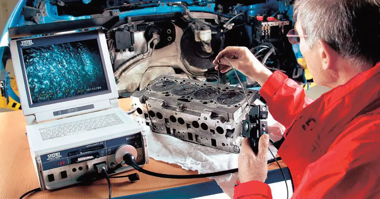 Mechanik bada głowicę silnika za pomocą endoskopu. Na ekranie widać wnętrze cylindra, co pomaga zrozumieć, co to znaczy TDI w kontekście diagnostyki.