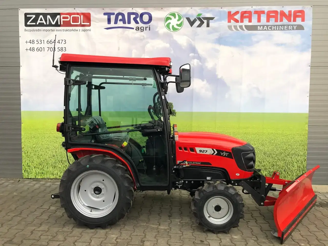 Czerwony, wielofunkcyjny traktorek ogrodowy VST 927 z kabiną i pługiem śnieżnym, gotowy do pracy w każdych warunkach.