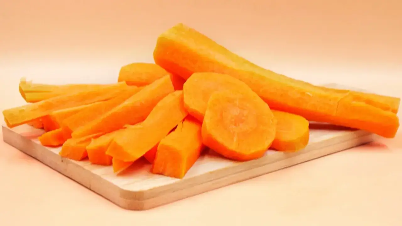Pokrojone marchewki na desce. Czy gotowana marchewka traci witaminy? Zobacz, jak wygląda surowa marchewka przed obróbką.