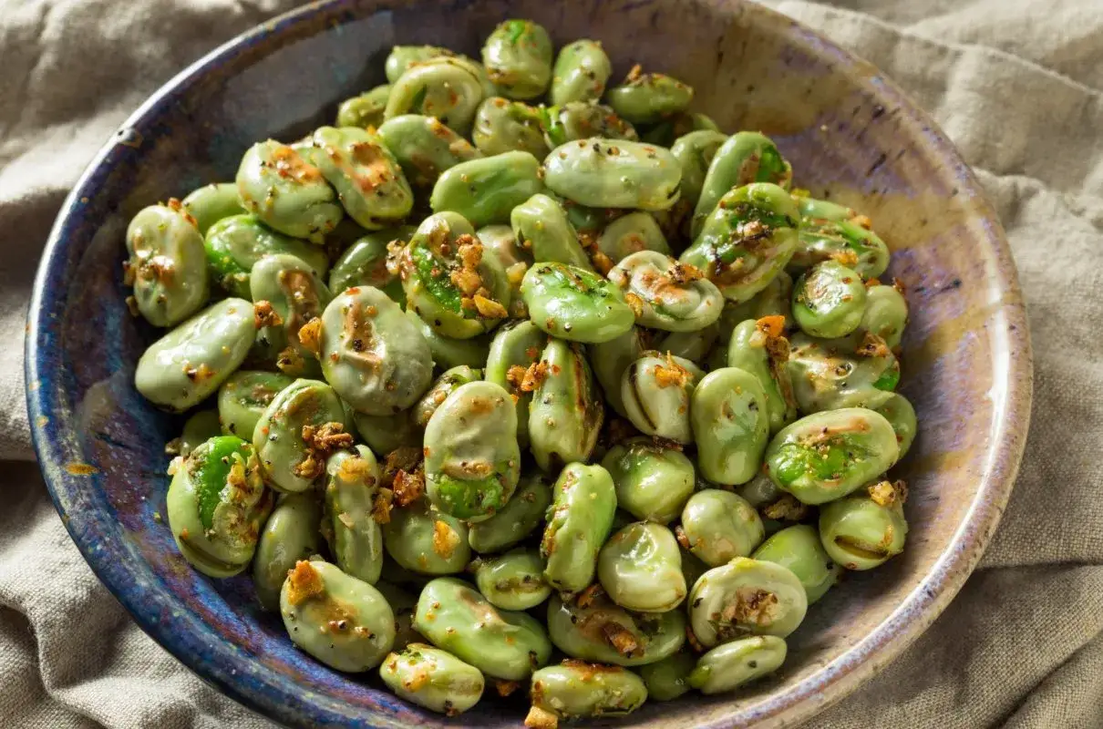 Gotowany bób z czosnkiem i przyprawami w misce. Idealny sposób, jak gotować bób na obiad.