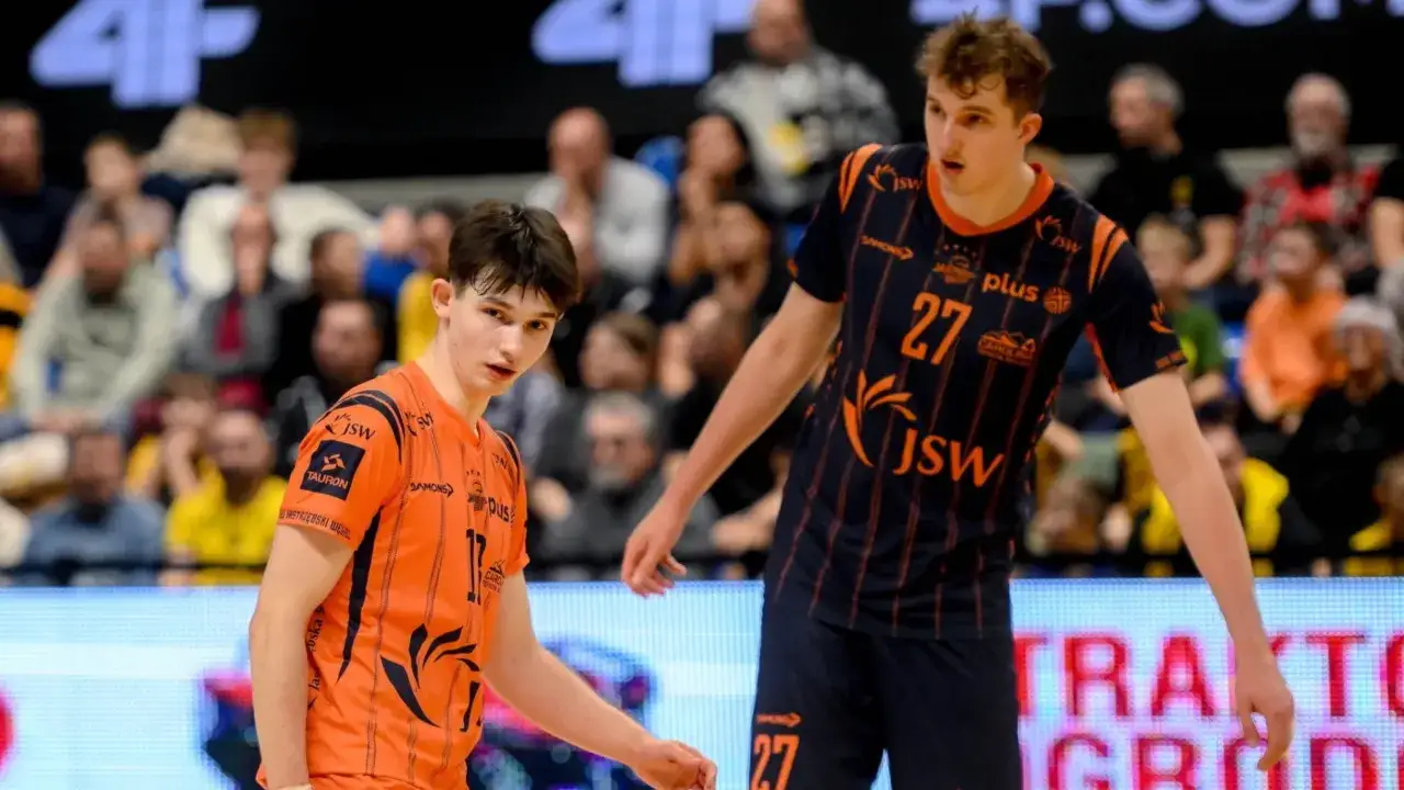 Dwóch młodych koszykarzy w pomarańczowych strojach z numerami 17 i 27. Jeden z nich patrzy w obiektyw, drugi jest w ruchu. W tle publiczność. To może być zapowiedź plus liga transfery.