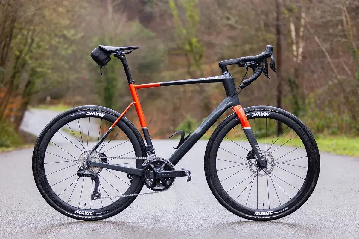 Nowoczesny rower szosowy endurance w kolorze grafitowo-pomarańczowym, gotowy na długie trasy.
