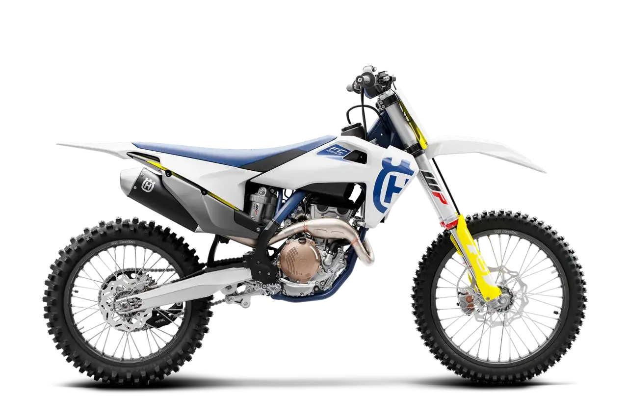 Biały motocykl Husqvarna FC 250 z niebieskim siedzeniem i ż&oacute;łtymi akcentami, gotowy do jazdy po torze.