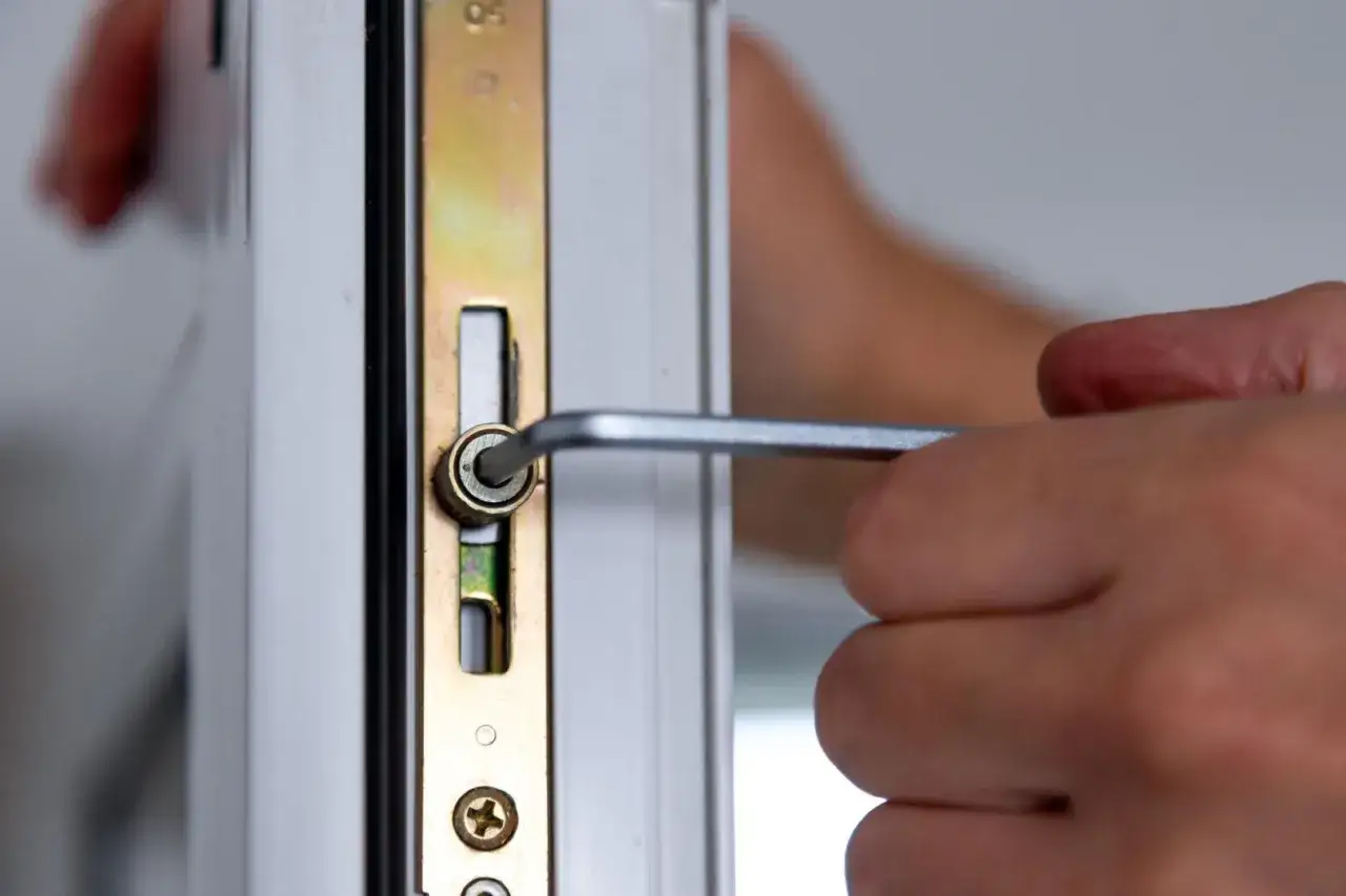 Dłoń dokręca śrubę imbusową, regulując okna plastikowe. To klucz do prawidłowego działania.