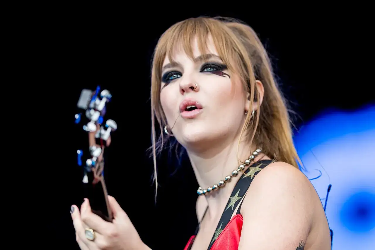 Victoria De Angelis z M&aring;neskin z charakterystycznym makijażem oczu, grająca na gitarze basowej.