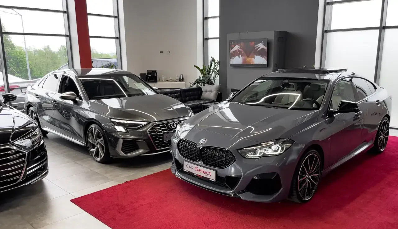Dwa luksusowe auta, Audi i BMW, na czerwonym dywanie. Zastanawiasz się, przy jakich dochodach opłaca się leasing?