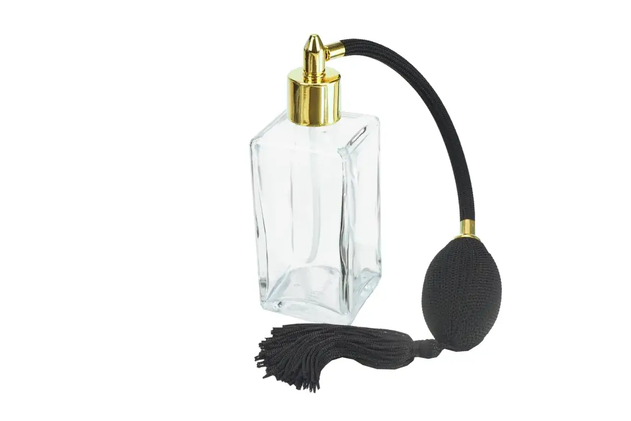 Elegancka, szklana buteleczka z atomizerem i czarnym pomponem, gotowa na przyjęcie ulubionych perfum.