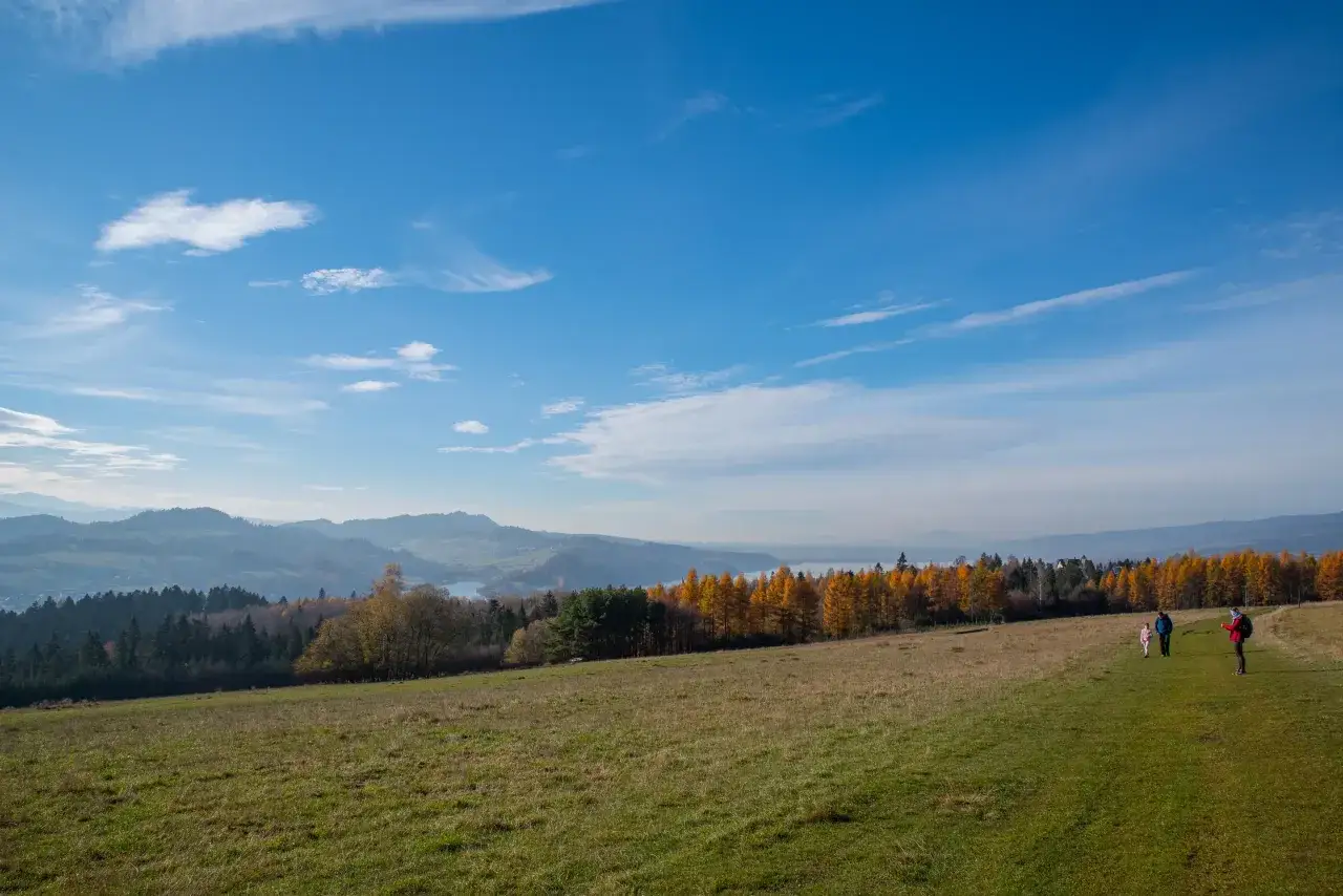 Jesienny spacer po polach z widokiem na Tatry. W oddali jezioro i lasy w jesiennych barwach.