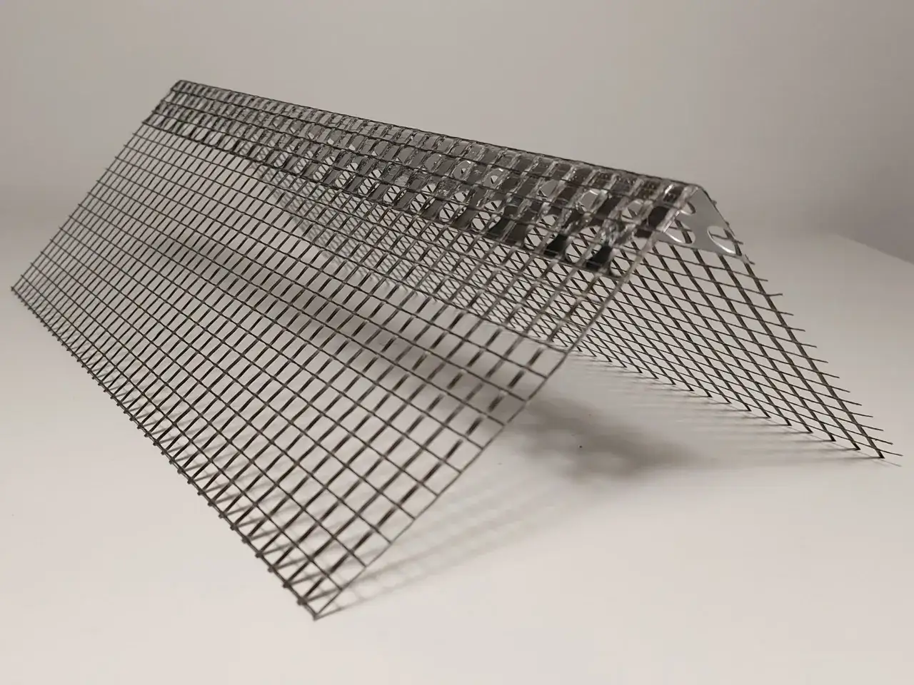 Metalowe narożniki do tynkowania, z siatką zbrojącą, zapewniają trwałe i estetyczne wykończenie krawędzi ścian.