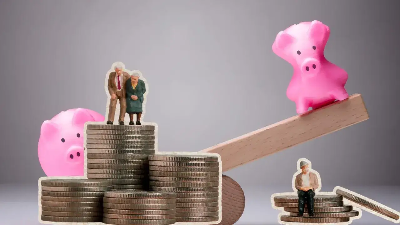 Dwie figurki starszych ludzi stoją na stosach monet obok skarbonki. To ilustracja co to jest okresowa emerytura kapitałowa.