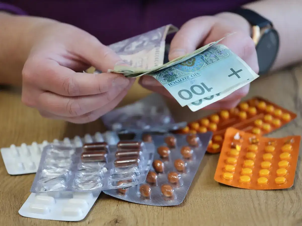 Ręce liczą pieniądze nad opakowaniami leków. Zastanawiasz się, ile można odliczyć od podatku za leki?