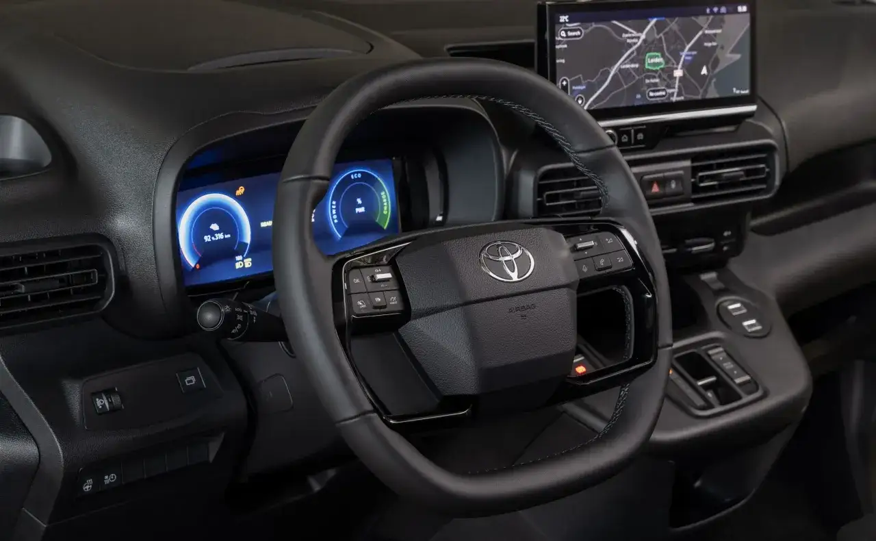 Wnętrze Toyoty Verso z cyfrowymi zegarami i ekranem nawigacji. Kierownica ze sterowaniem multimediami.