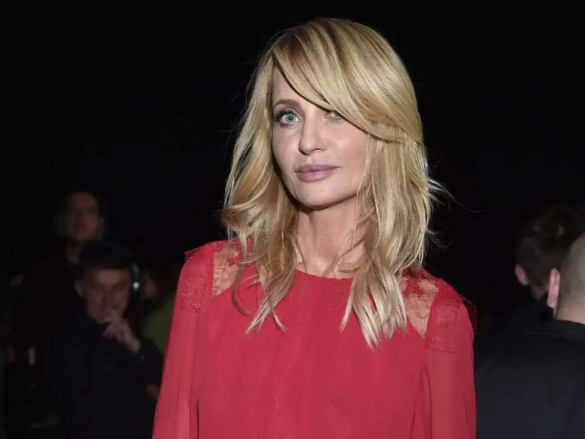 Blond włosy z cieniowanymi pasmami, idealne cieniowane odmładzające fryzury dla 50-latek. Kobieta w czerwonej sukience.