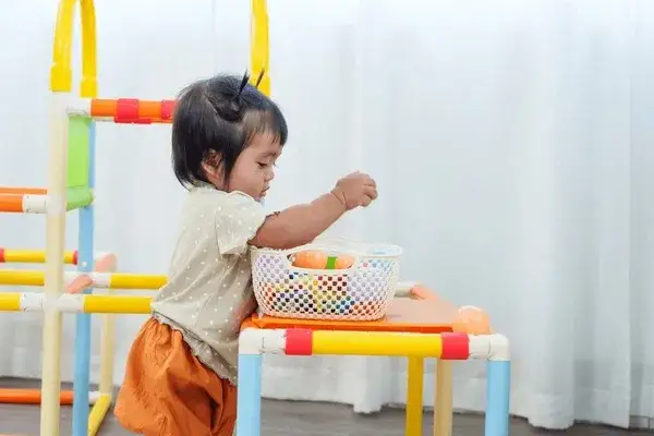 Szczęśliwe niemowlę bawiące się zabawkami sensorycznymi, odkrywające dłonie