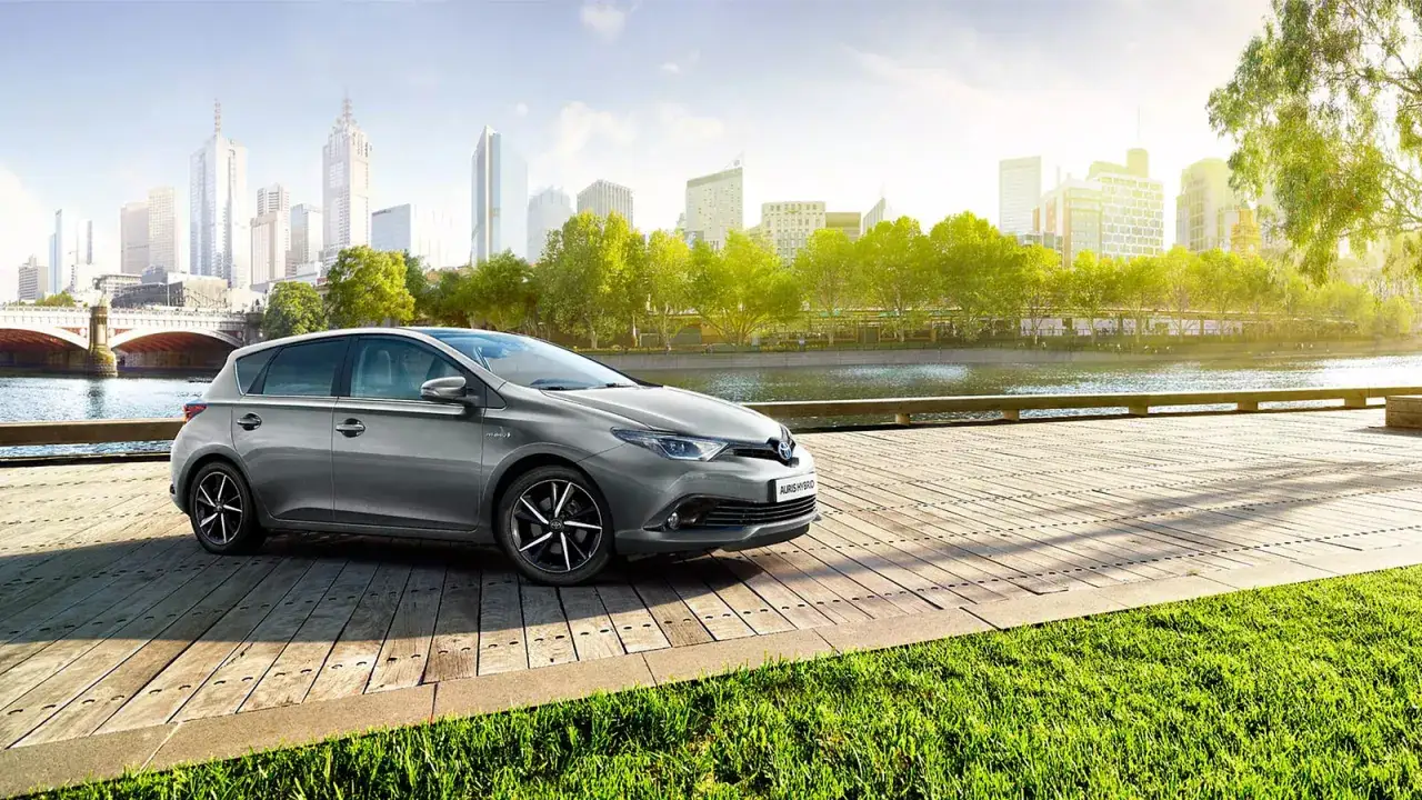 Szary Toyota Auris Hybrid na drewnianym pomoście. Zastanawiasz się, czy rozrząd w tym modelu to pasek czy łańcuch?