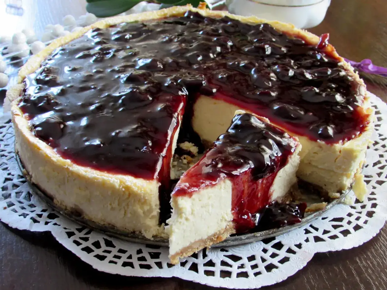 Pyszny sernik z polewą z ciemnych owoców. Idealnie sprawdzi się jako dodatek, co dać na wierzch sernika.