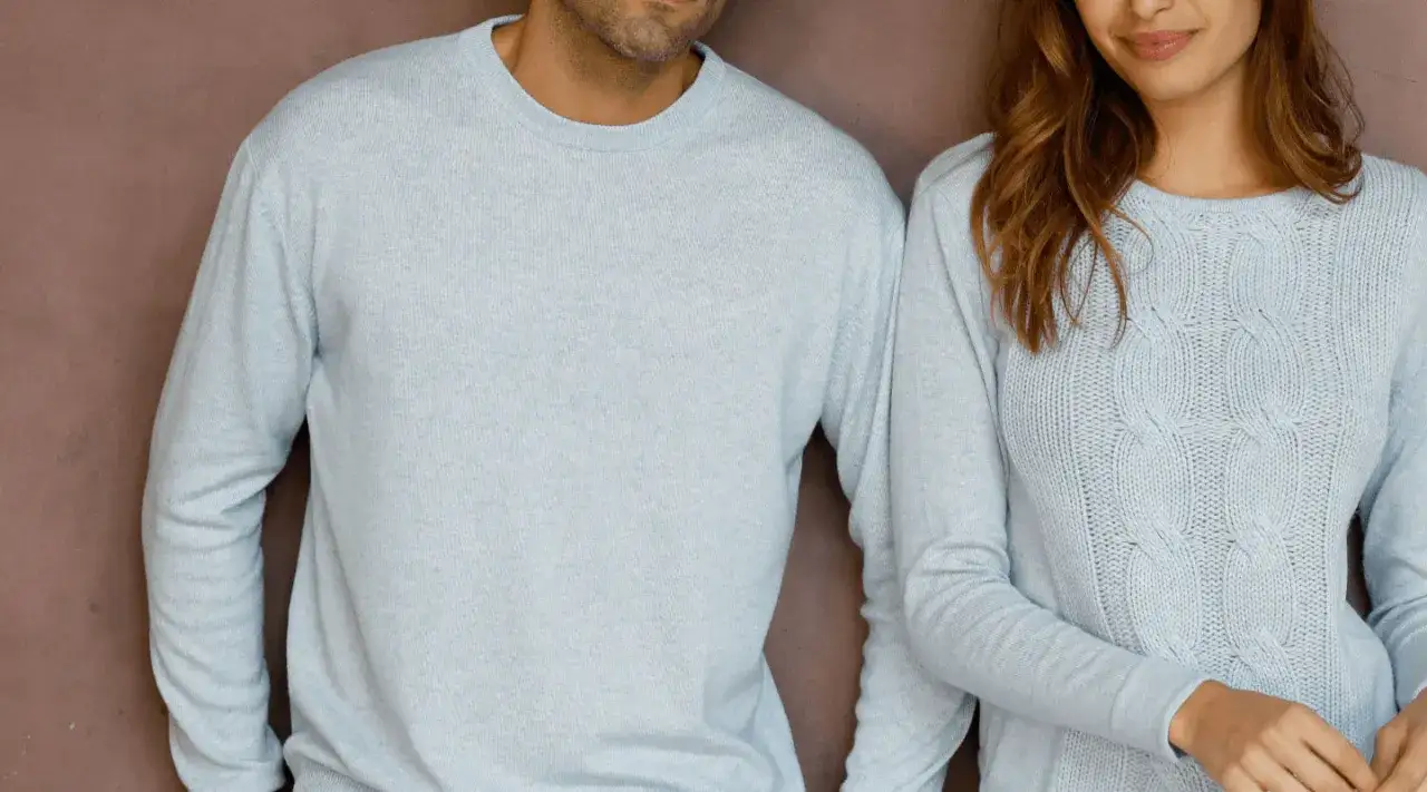 Para pozuje w jasnoniebieskich swetrach. Jej sweter ma warkoczowy wz&oacute;r, a jego sweter jest gładki. To jest właśnie to, co to kaszmir &ndash; miękkość i ciepło.