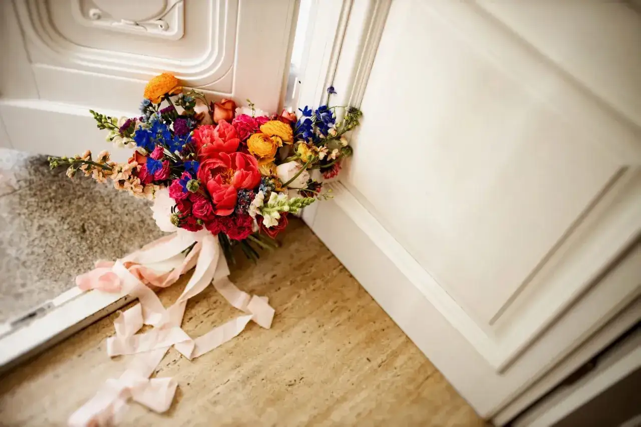 Kolorowy bukiet ślubny z różowymi wstążkami. Czy warto wynająć wedding plannera na samą koordynację dnia ślubu?