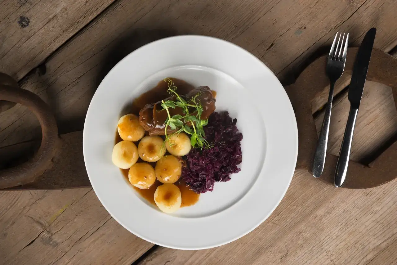 Talerz z roladą śląską, kluskami i modrą kapustą w restauracji