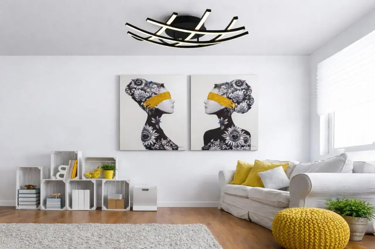 Nowoczesny plafon sufitowy, idealny jako jaki plafon do łazienki, oświetla salon z dwoma obrazami i białym narożnikiem.