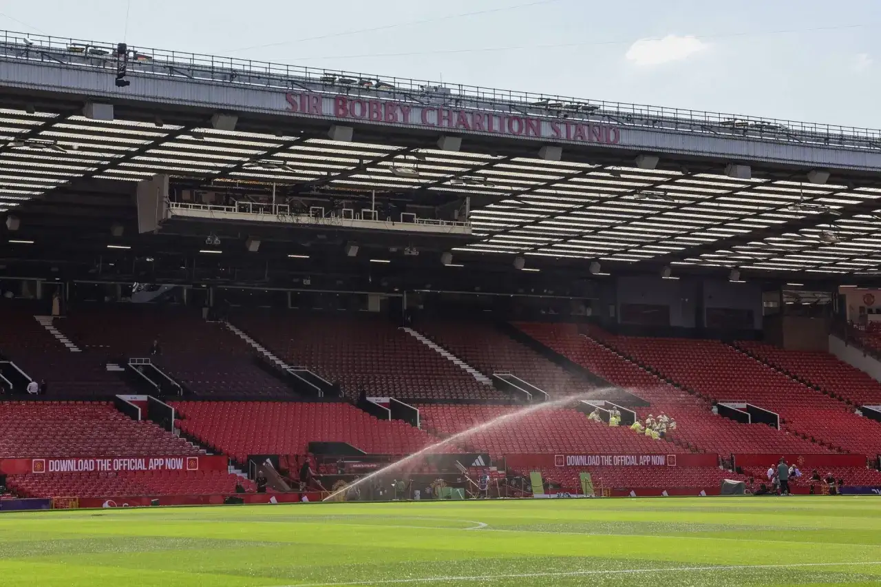 Stadion Old Trafford, trybuna Sir Bobby Charlton. Czerwone diabły Manchester United czekają na mecz, a boisko jest podlewane.