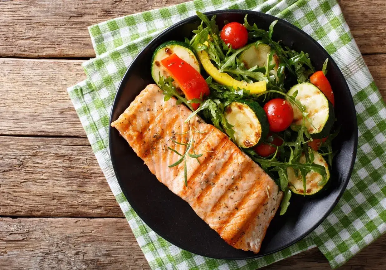 Grillowany łosoś z sałatką z cukinii, pomidork&oacute;w i papryki. Idealny sos do pieczonego łososia podkreśla smak dania.