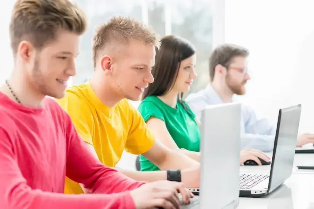 dzieci uczące się programowania na tabletach lub laptopach