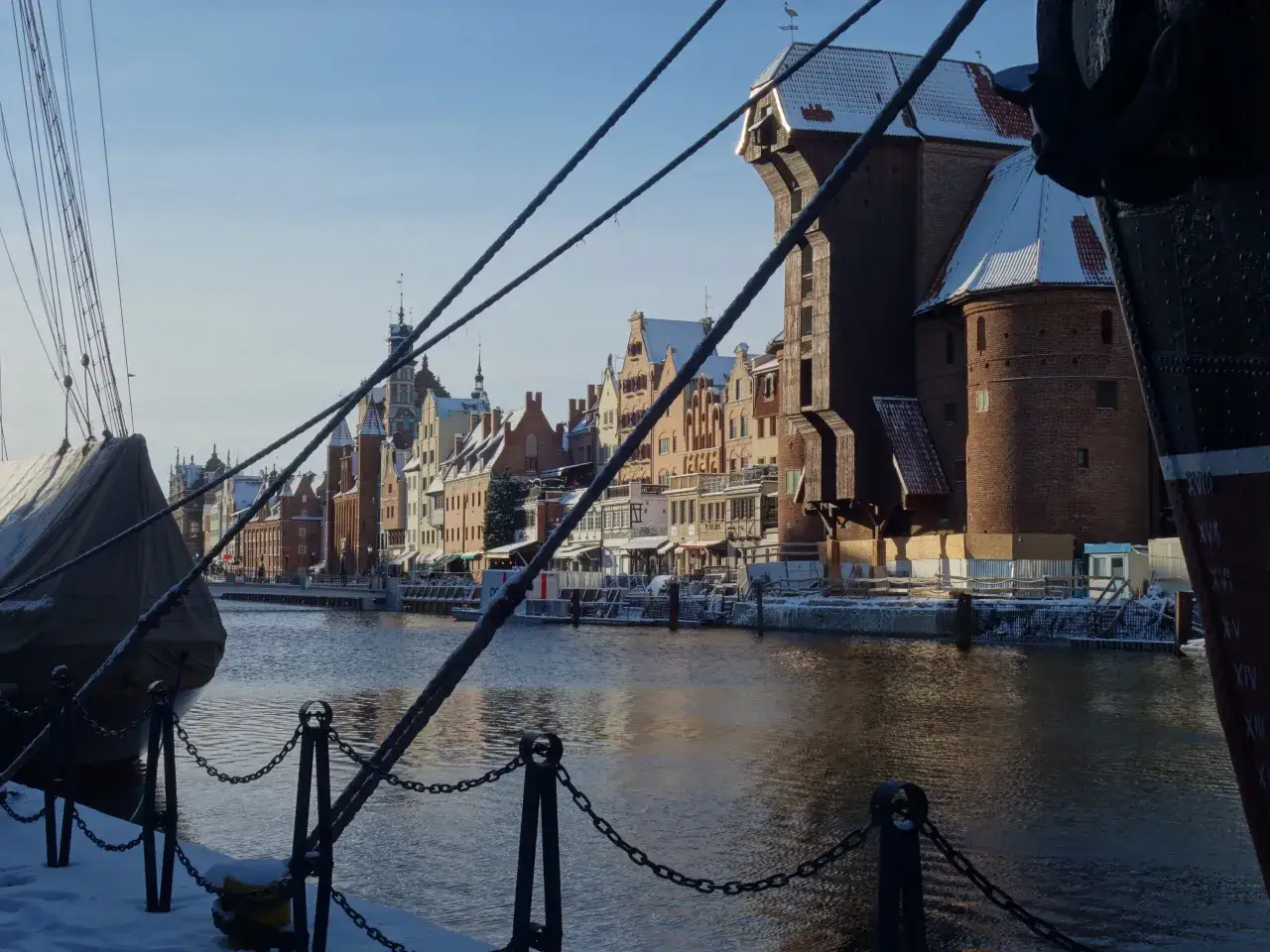 Zimowy widok na Motławę, historyczne kamienice i Żur w Gdańsku. Czy Gdańsk jest nad morzem? Tak, to miasto portowe nad Bałtykiem.