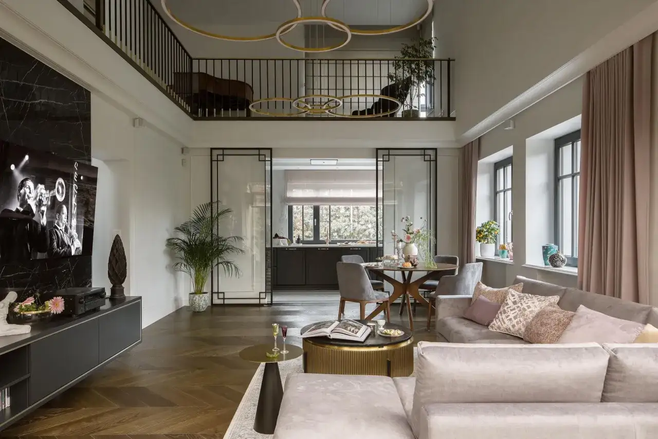Eleganckie wnętrze w stylu modern classic: dwupoziomowy salon z widokiem na kuchnię, wygodna sofa, stolik kawowy i jadalnia.