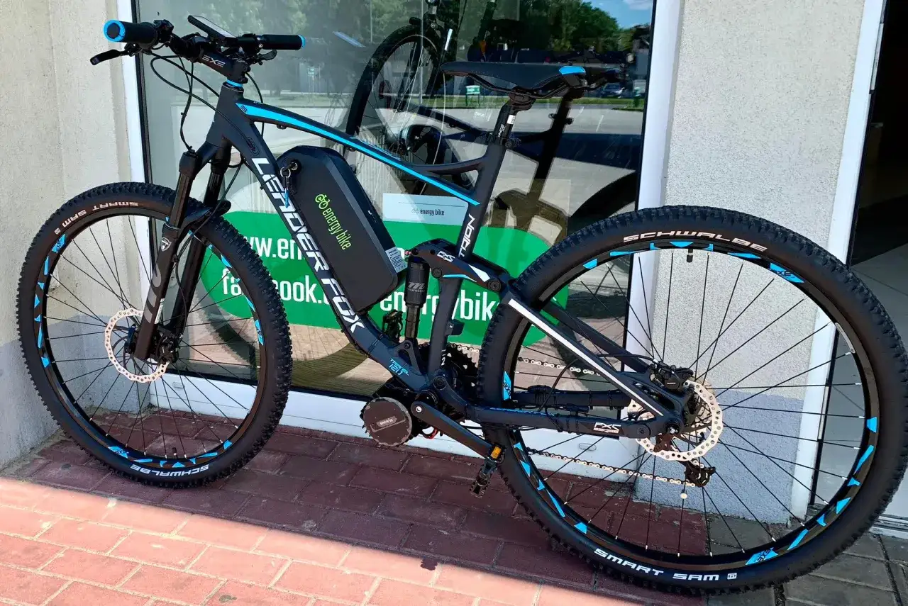 Czarny rower g&oacute;rski z niebieskimi akcentami, wyposażony w koło elektryczne do roweru 26 cali. Bateria i silnik Bafang.