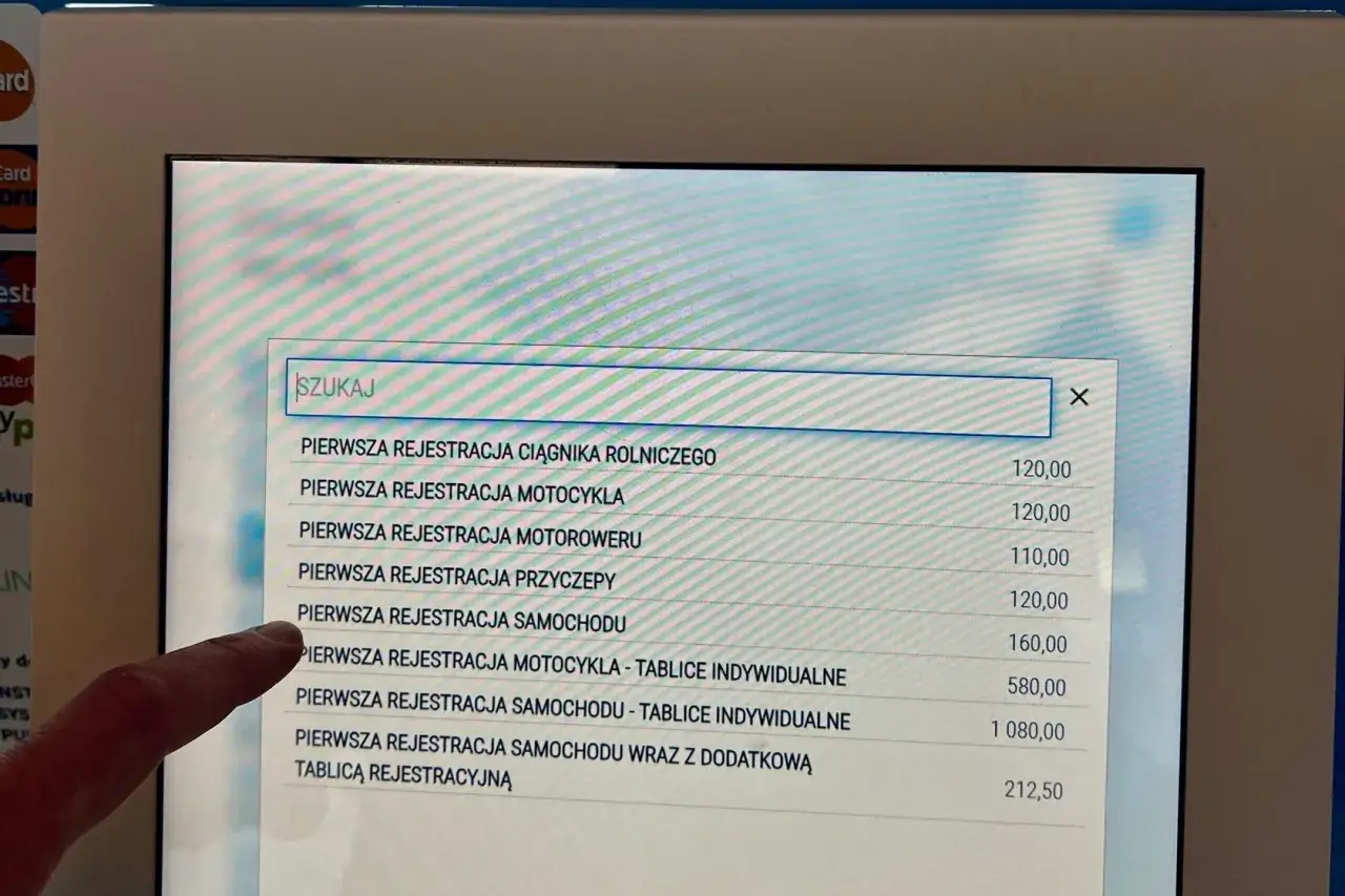 Palec wskazuje na ekran, gdzie wyświetla się lista usług, m.in. 