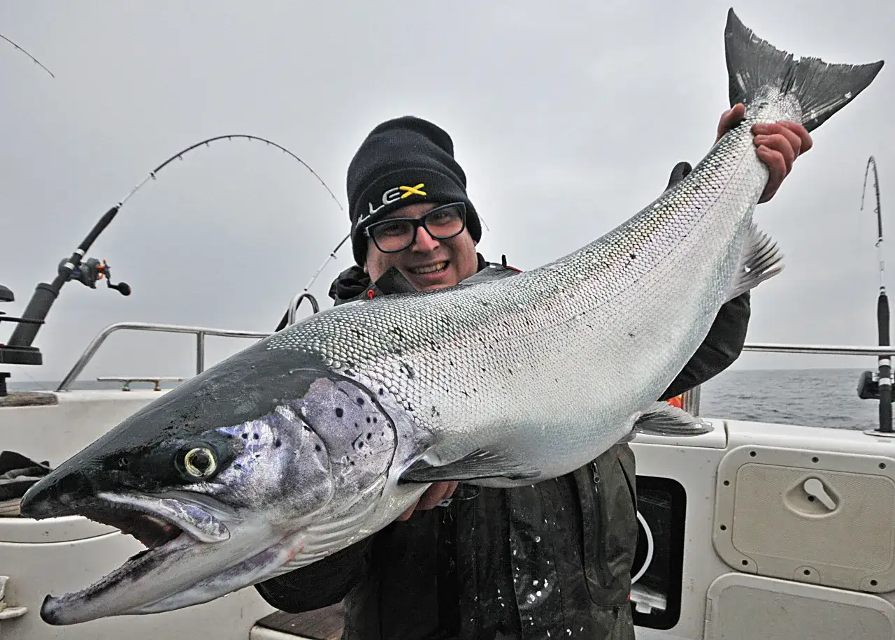 Szczęśliwy wędkarz trzyma ogromnego łososia złowionego w Bałtyku. To dowód, że w Bałtyku są łososie!
