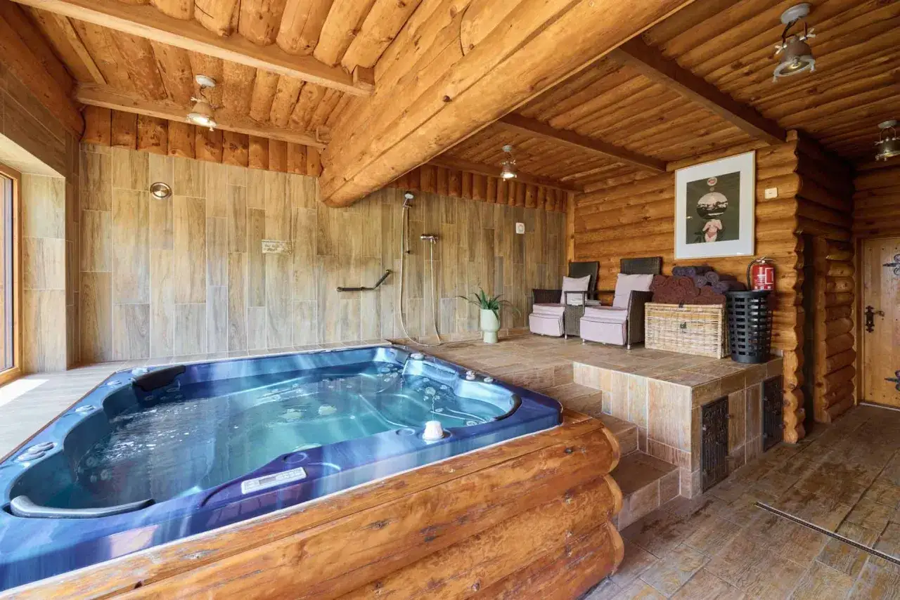 Relaks w domkach nad jeziorem dolnośląskie: jacuzzi, prysznic i przytulne fotele w drewnianym wnętrzu.