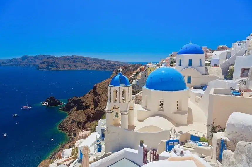 Plaża na Santorini z białymi domkami i błękitnym morzem