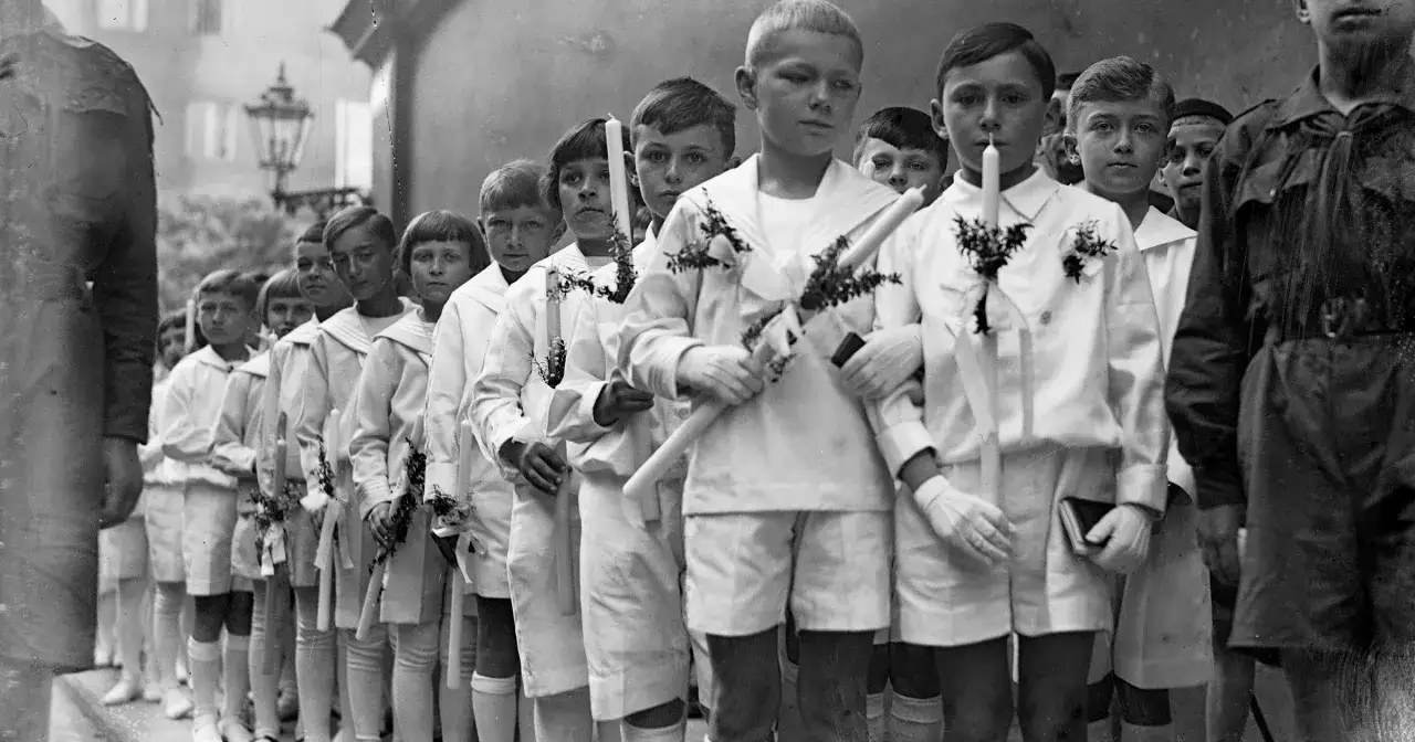 Dzieci w strojach komunijnych przed kościołem