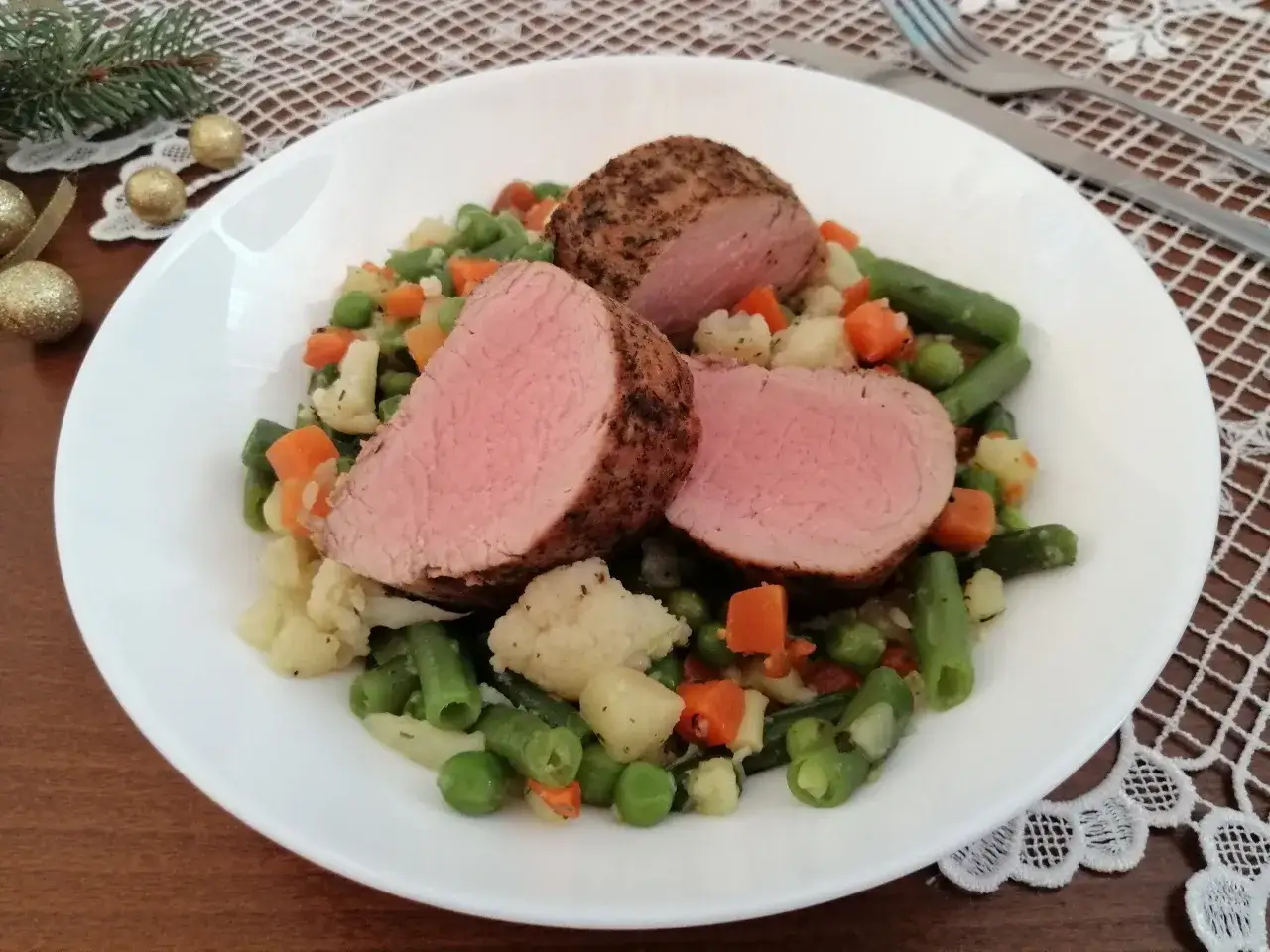 Soczysta polędwiczka wieprzowa na warzywach. Dowiedz się, dlaczego polędwiczka wieprzowa jest sucha po upieczeniu i jak temu zapobiec.