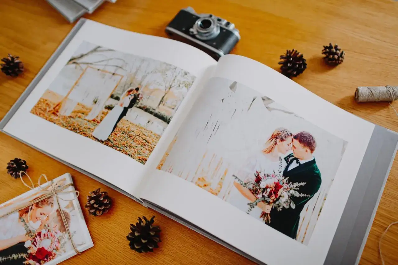 Otwarty album ślubny z pięknymi zdjęciami pary. Wklejanie zdjęć do albumu to piękny spos&oacute;b na zachowanie wspomnień.