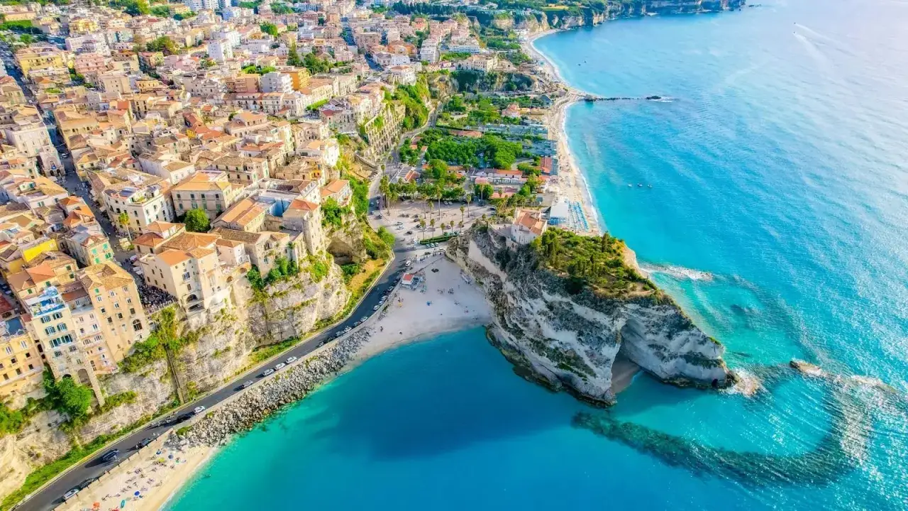 Włochy we wrześniu: malownicze miasteczko na klifie nad turkusowym morzem. Idealne miejsce na wakacje.