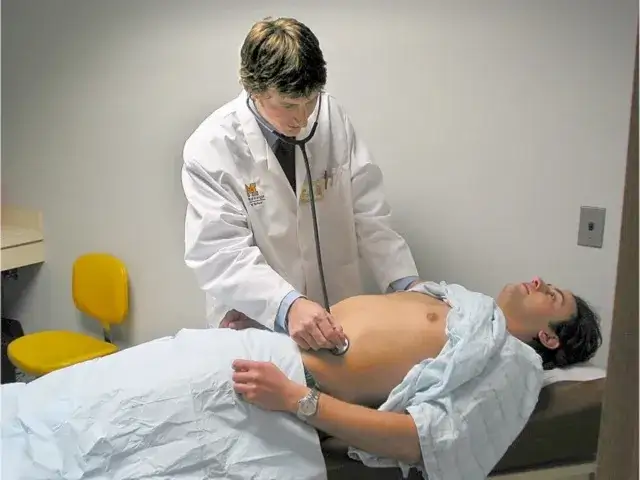 Lekarz rodzinny badający pacjenta z b&oacute;lem brzucha