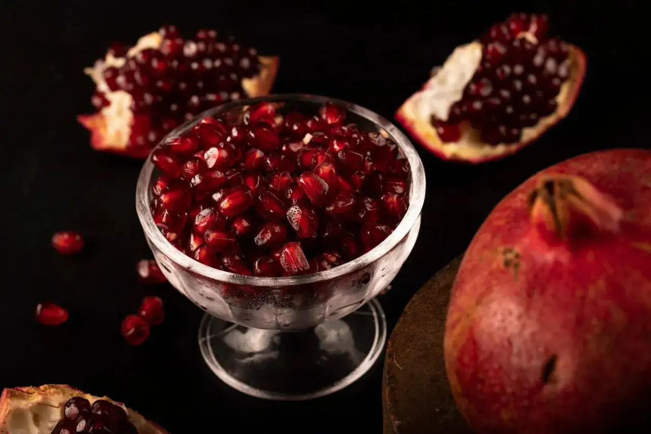 Osoba wydobywająca ziarenka granatu