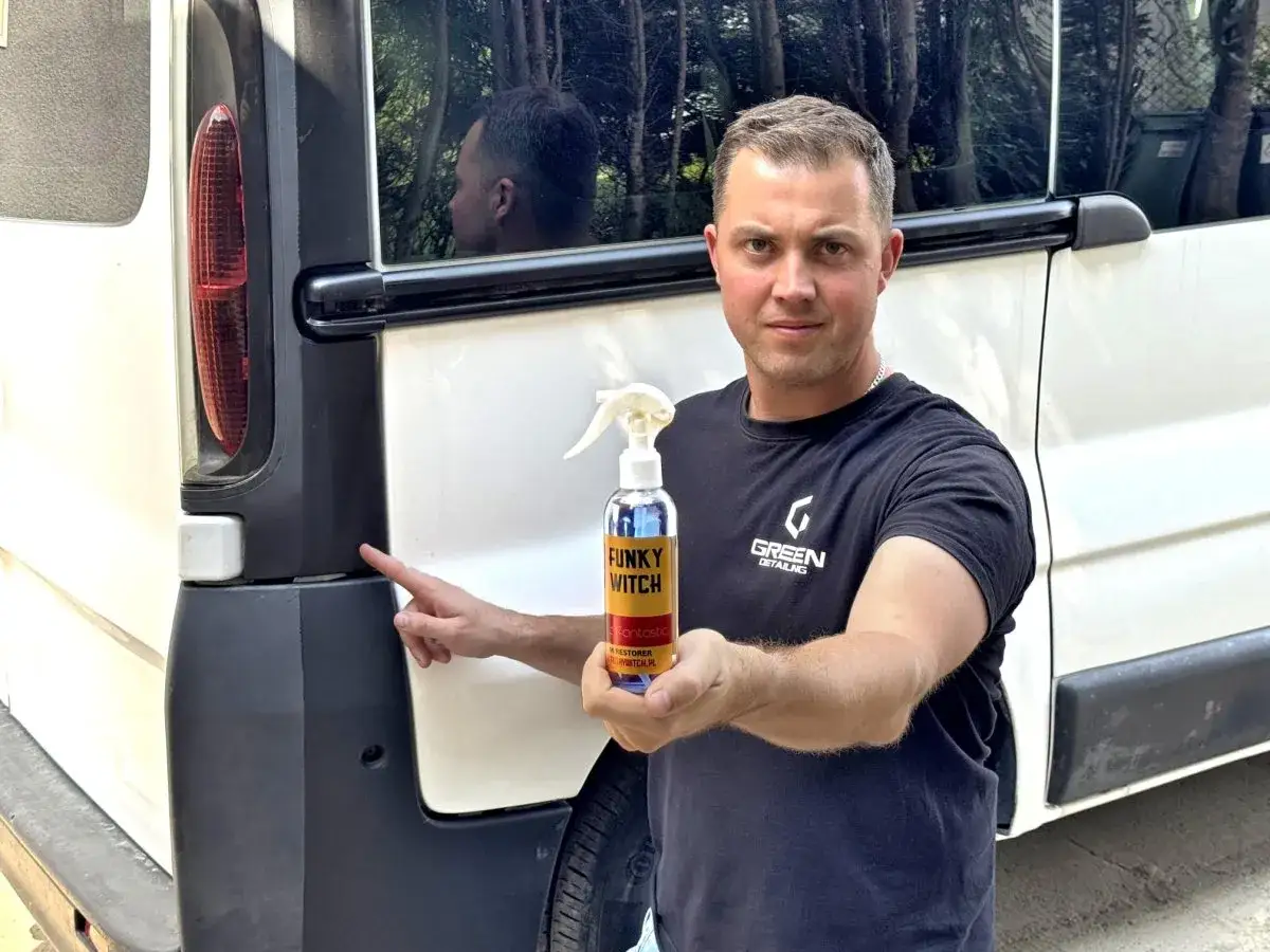 Mężczyzna prezentuje czernidło do zderzaków, które przywraca im głęboki, czarny kolor.