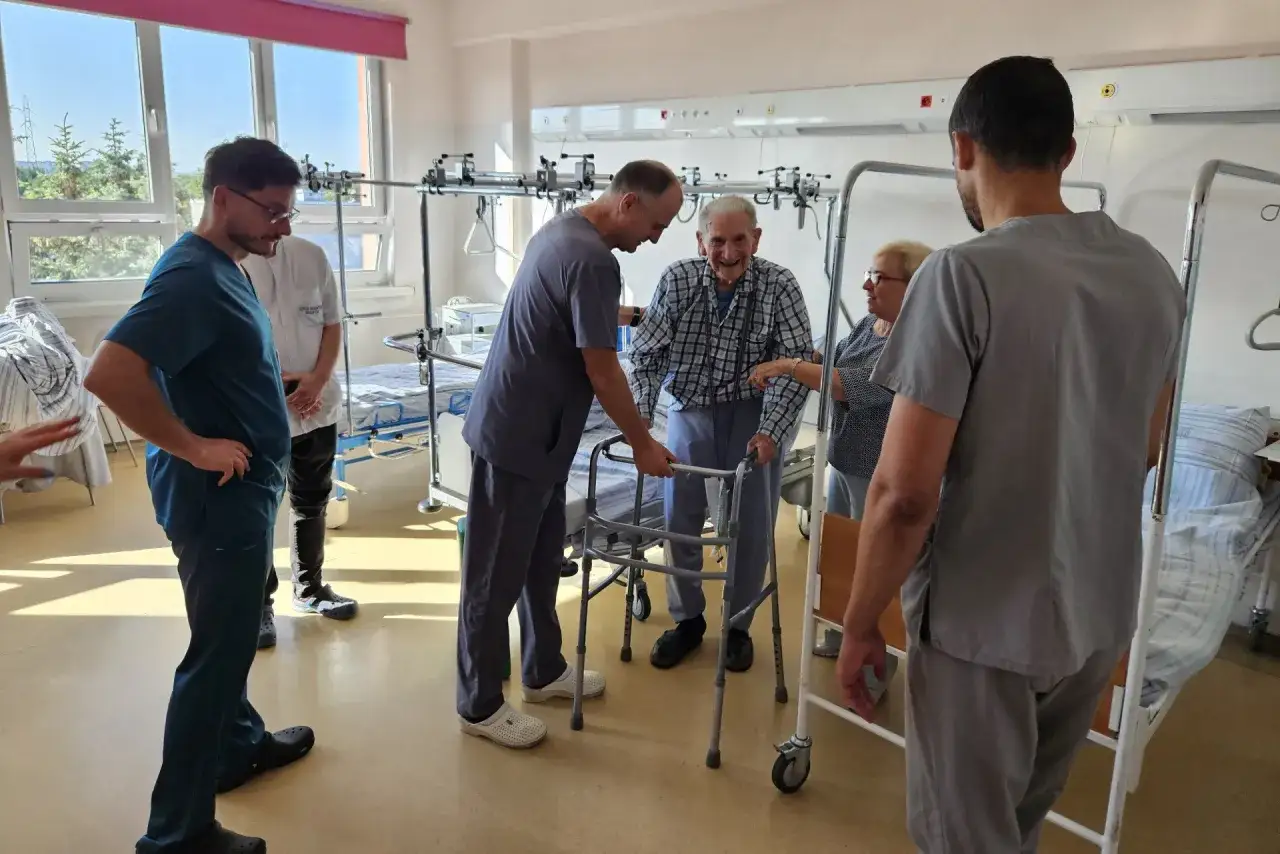 pacjent po operacji biodra w szpitalu chodzi o kulach