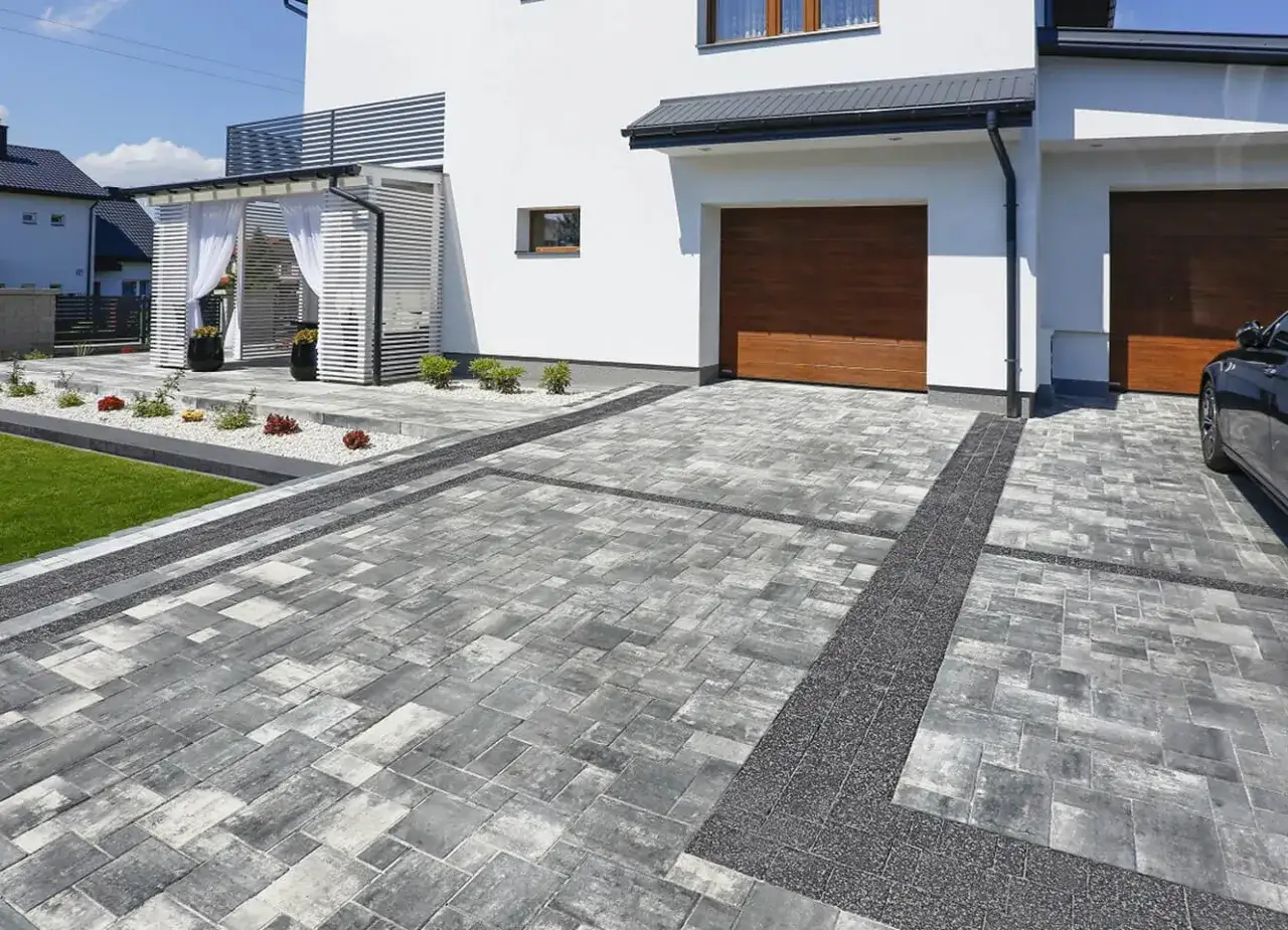 Nowoczesna kostka brukowa przed domem, tworząca stylowe podjazdy i alejki. Inspiracje dla Twojego ogrodu.