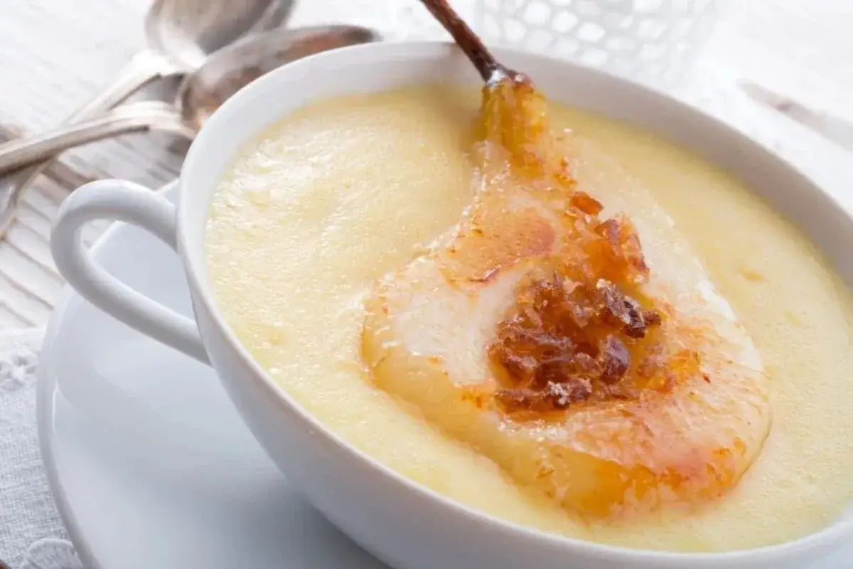 Grysik, czyli kasza manna, podany w białej filiżance z karmelizowaną gruszką.