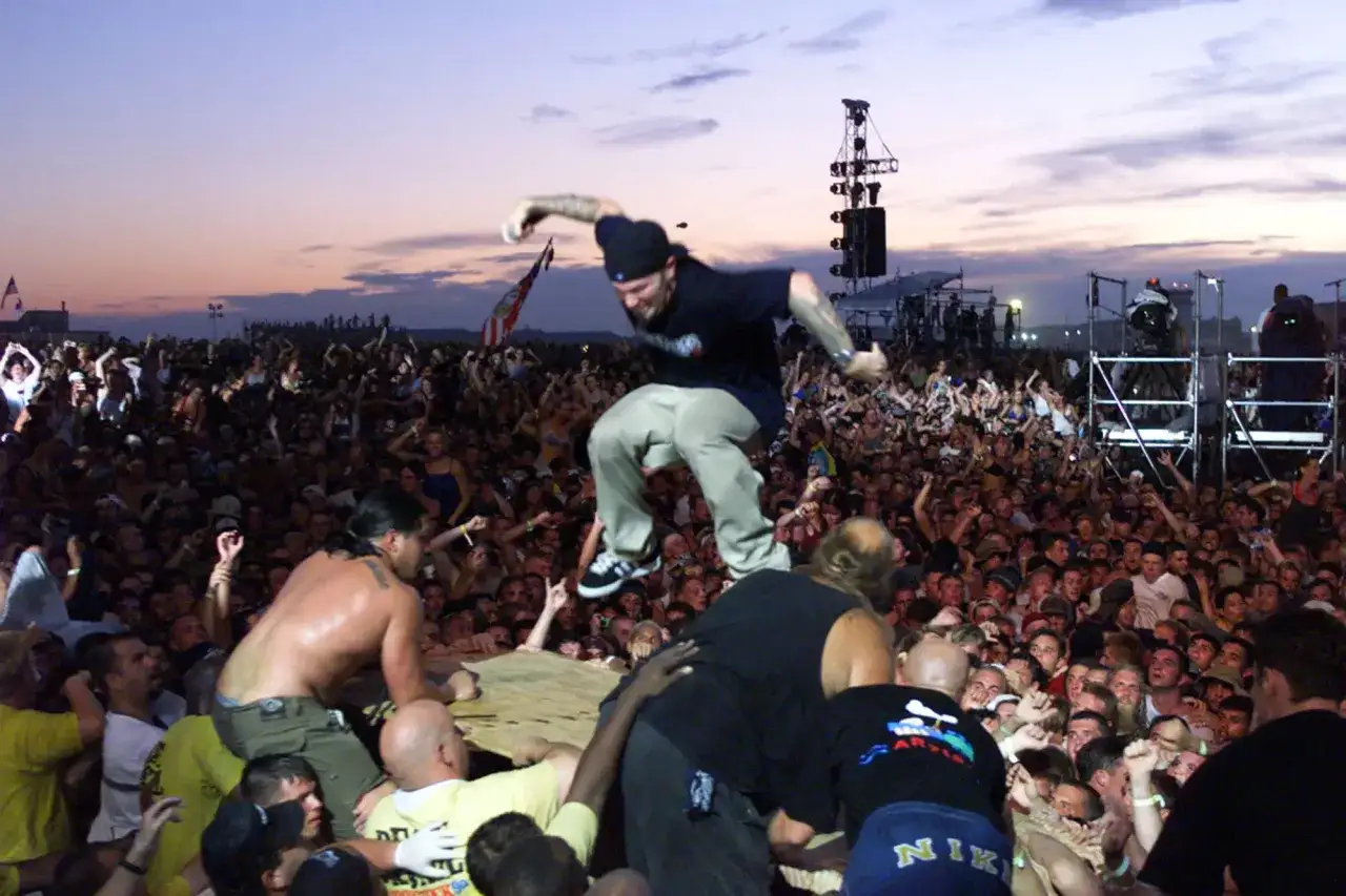 Tłum na Woodstock 99, skaczący człowiek, chaos i niebezpieczeństwo, kt&oacute;re mogły prowadzić do ofiar.