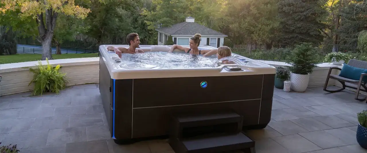 Rodzina relaksuje się w wanna spa jacuzzi na tarasie, otoczona zielenią.